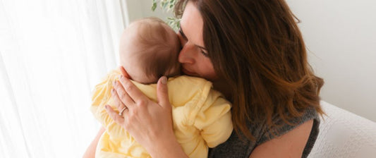 mum cuddling baby in yellow sleeping bag