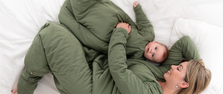  A mother and her baby, both in matching green sleeping bags